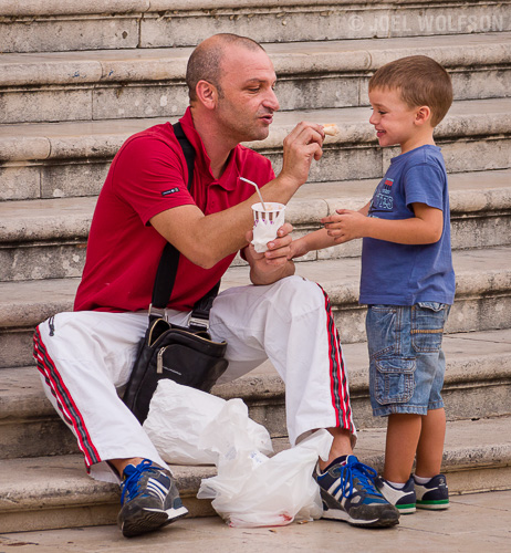 I found these stairs in a main square of a village in Sicily where there were a lot of people coming and going. I just waited for things to happen- one of which was a nice moment with this father and his son sharing some lunch. Aside from a nice moment- the man, his attire and the old stone steps let the viewer know this is in Italy