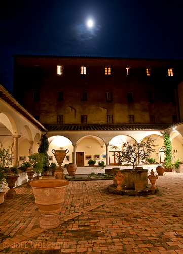 This is one of my favorite places in the town where I hold my Villages of Tuscany workshop. It's a courtyard of a centuries old convent that is now a hotel. At night there are very few people and the lighting along with the moon through a misty sky adds drama to the feel of it. 