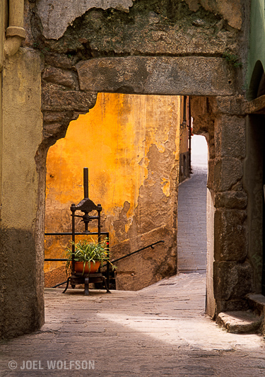 Olive press wine press ancient antique old world Italy with yellow wall